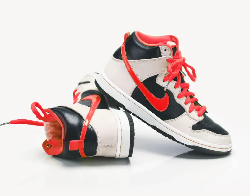 Nike Dunk High sneakers in black, beige, and red with bright red laces.